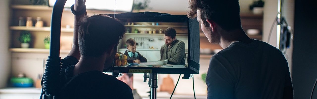 two people by a monitor on a film set